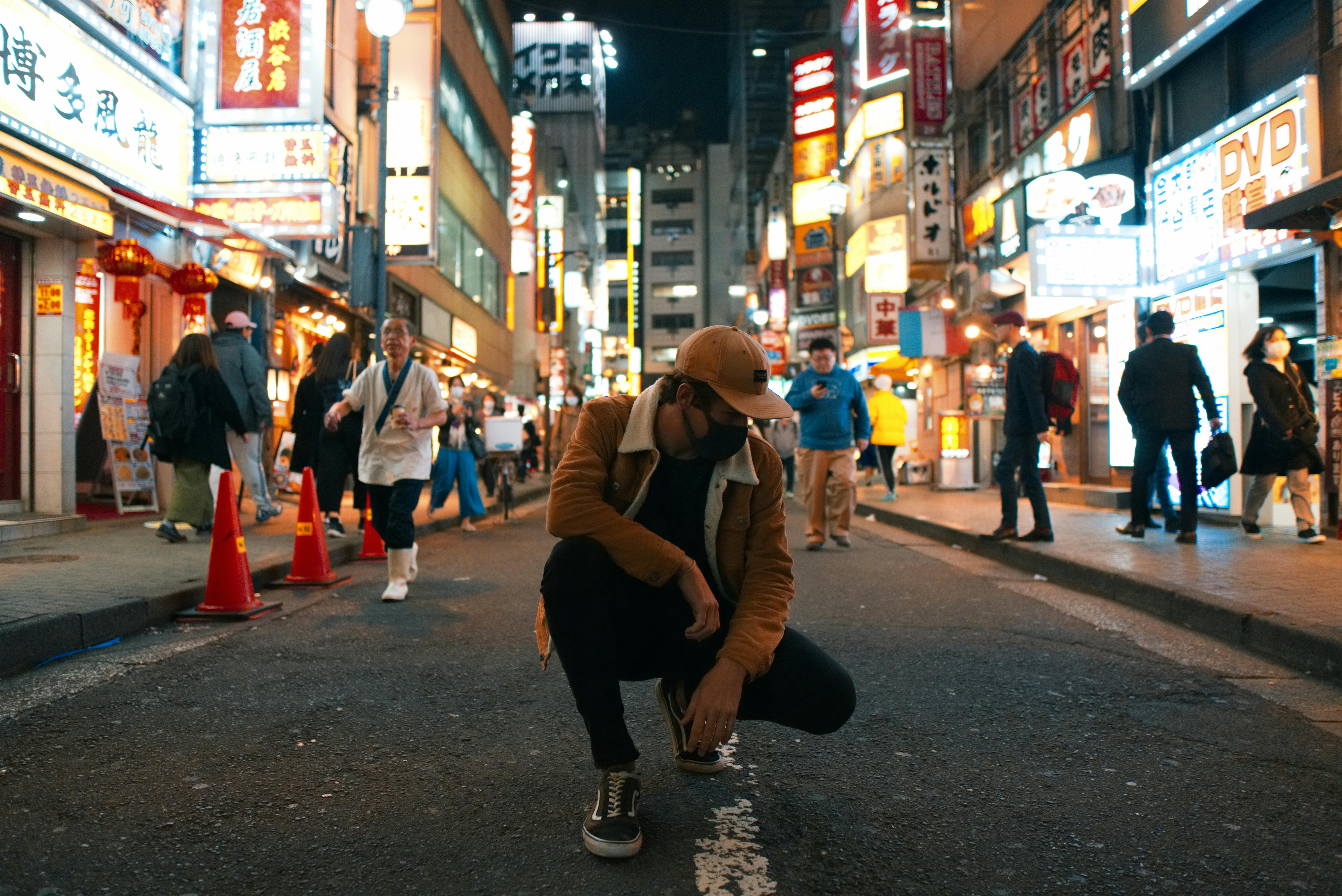 Dynamic night street scene in Tokyo with neon lights and bustling activity.