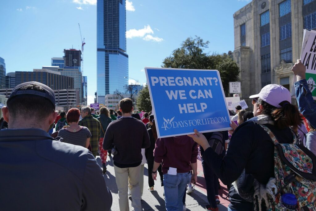 A group of people walking down a street holding signs