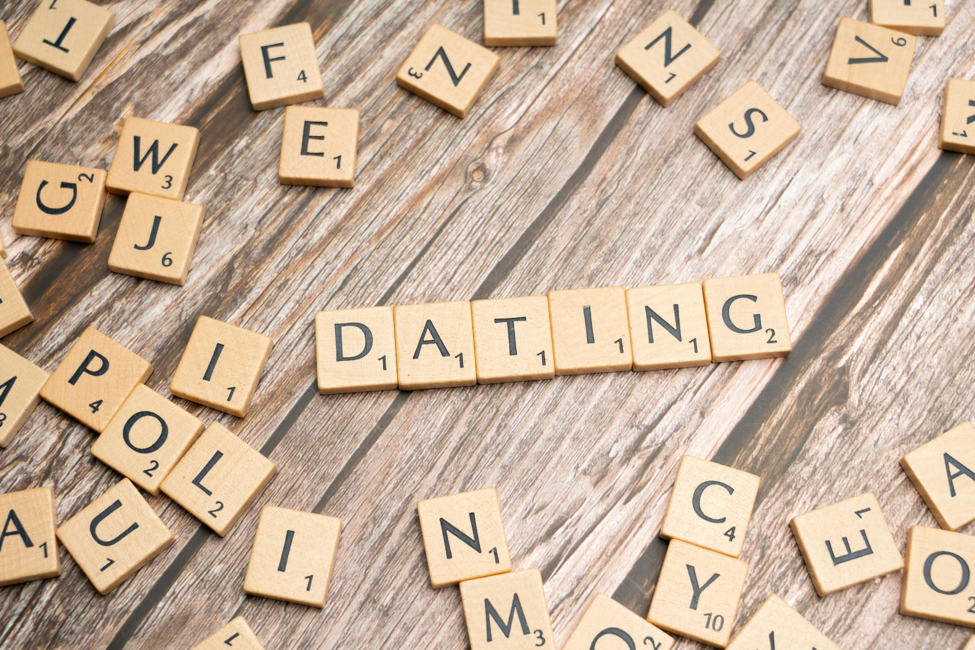 Scrabble tiles forming 'Dating' on a wooden background, representing relationships.