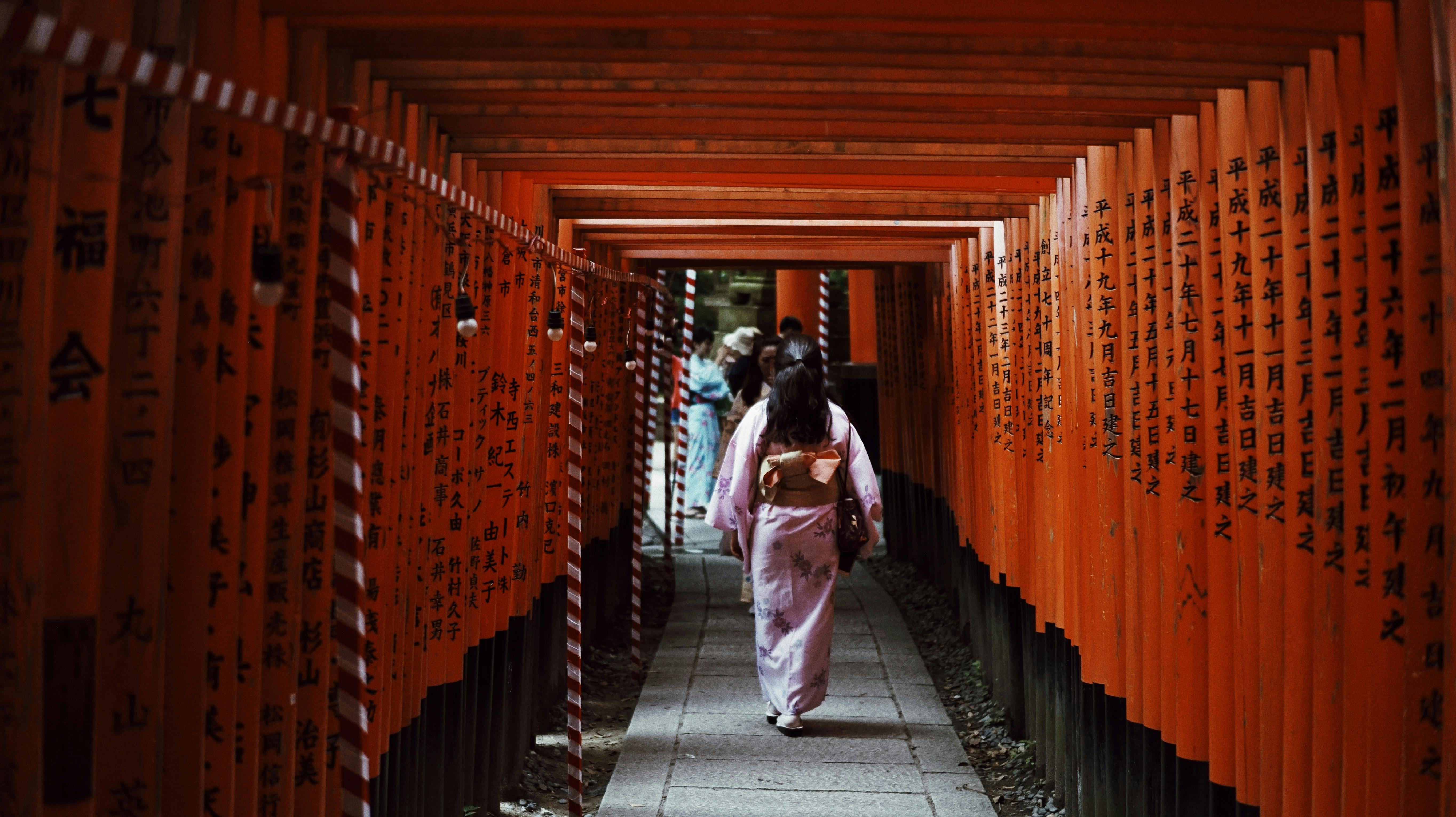 A peaceful view of a woman standing near a Chozuya for purification.