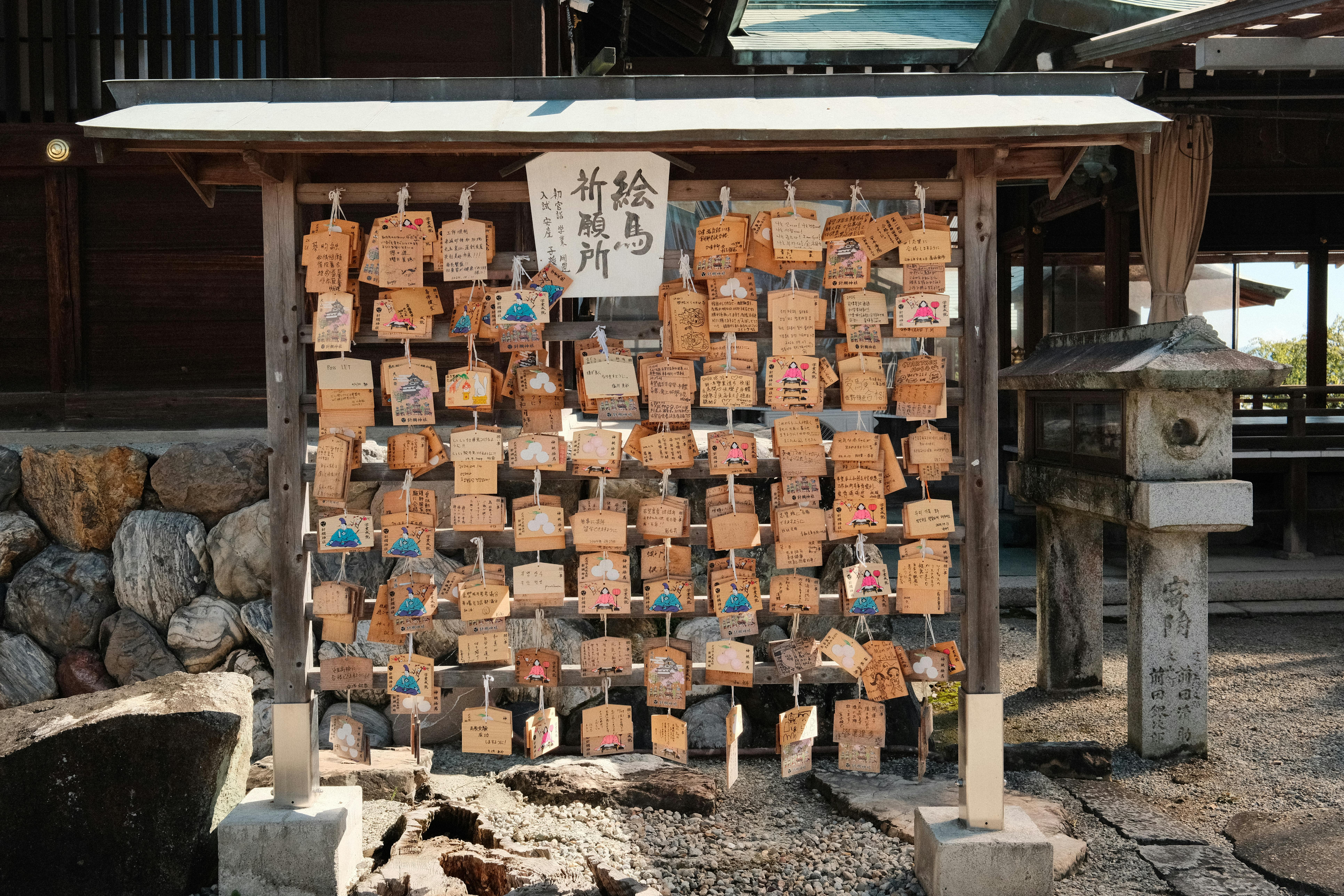 A peaceful view of ema prayer plaques hanging at a Shinto shrine.